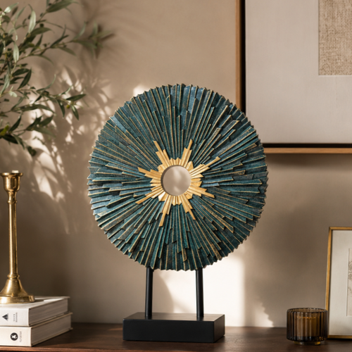 Teal and gold modern sunburst decorative sculpture displayed on a luxury wooden console table in a contemporary living room with warm neutral décor.