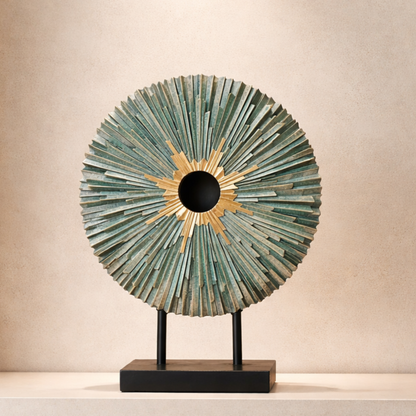 Teal and gold sunburst sculpture displayed as a standalone decorative piece on a minimalist console table in a modern living space