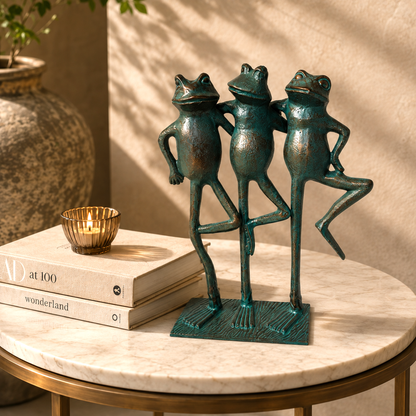 Three Frogs decorative metal sculpture with verdigris finish displayed on a marble side table in a premium luxury living room featuring a warm beige Venetian plaster wall and elegant contemporary décor.