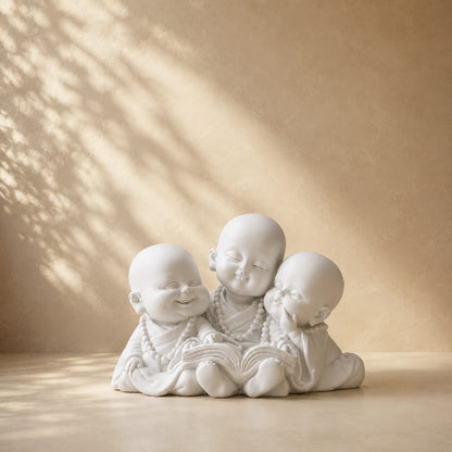 Premium Three Little Monk Reading Figurine in white resin displayed against a warm beige luxury backdrop with soft natural light, elegant home décor accent.
