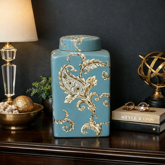 Turquoise ceramic decorative jar with white paisley design styled on dark polished wooden console table against a dark charcoal wall for luxury home decor.