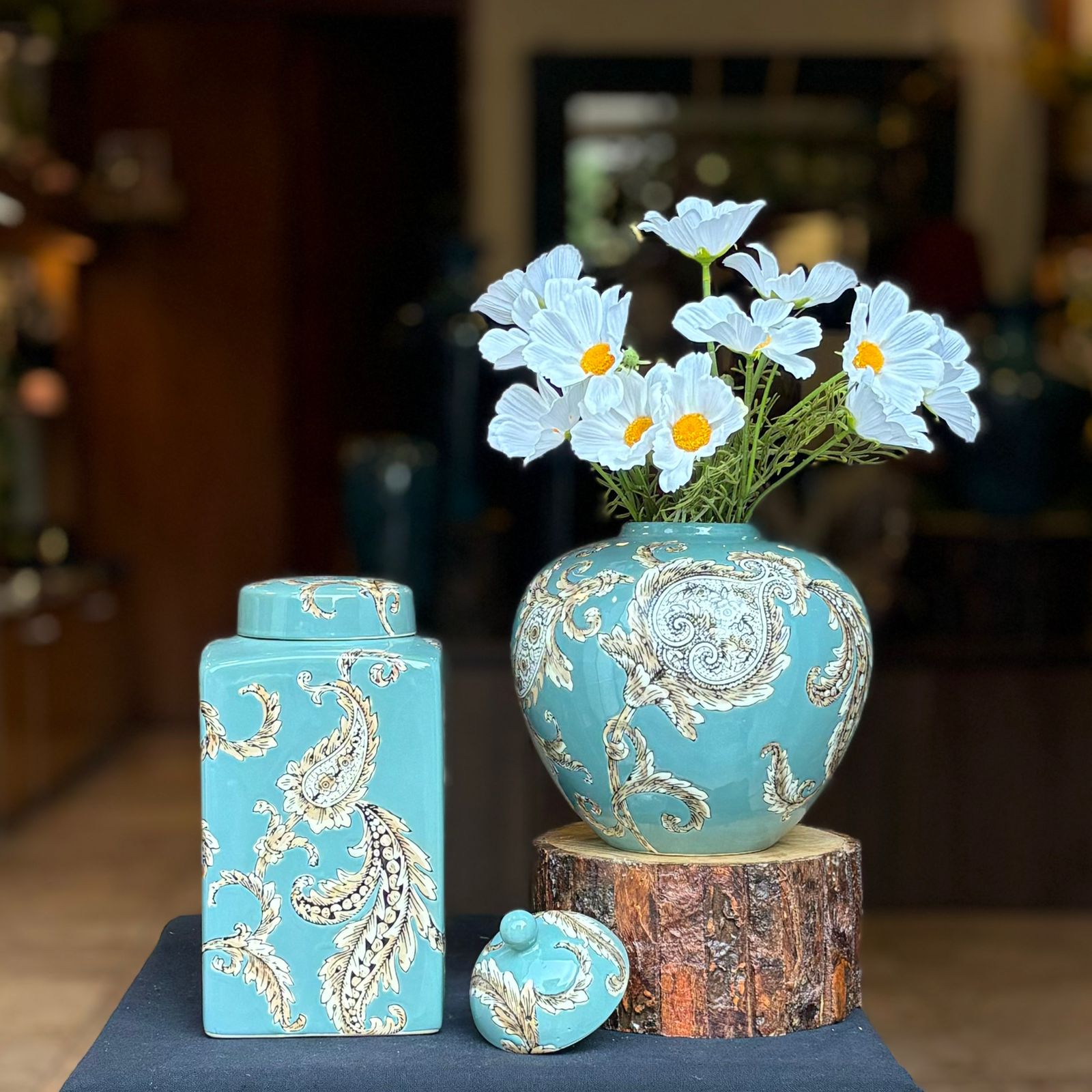 A tall, rectangular ceramic ginger jar in a vibrant turquoise glaze featuring an intricate cream and black hand-painted paisley floral motif.
