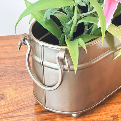 Detailed close-up of handcrafted vintage brass indoor planter handle, highlighting metal ring design and rectangular planter craftsmanship