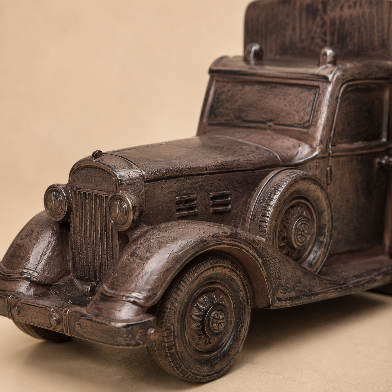 Close-up macro view of vintage car bookends highlighting the antique bronze finish, detailed headlights, front grille, textured bodywork, and wheel craftsmanship, ideal for luxury home office and bookshelf décor.