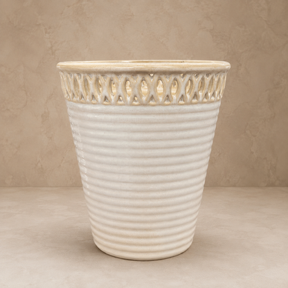Front view of a cream glazed ceramic planter with decorative cutwork rim and ribbed texture for indoor and outdoor décor.