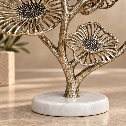 Close-up of natural white marble base and textured gold metal stem of a luxury decorative floral sculpture.