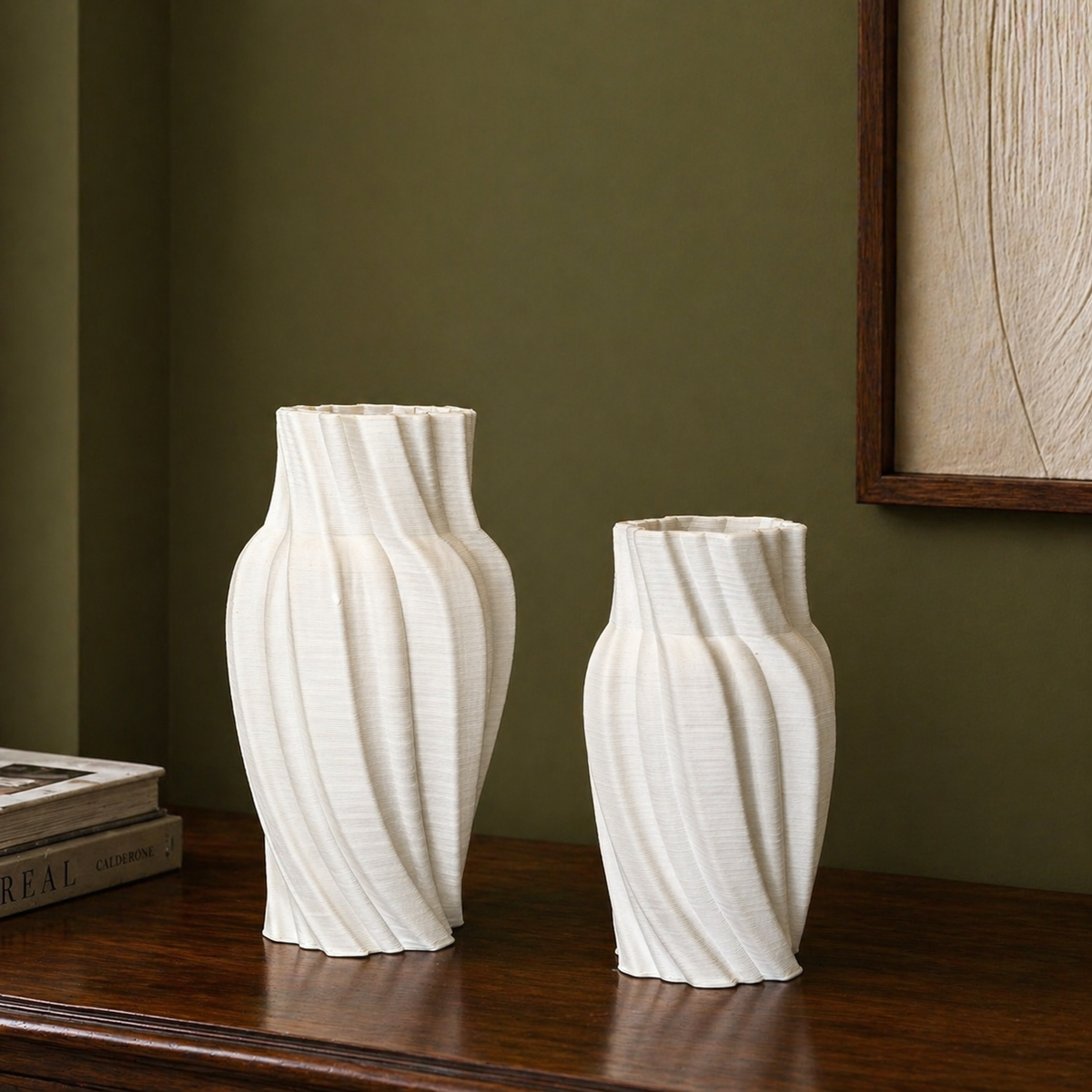 Set of white spiral ribbed ceramic vases styled on a dark polished wood console against an olive green wall in a modern minimalist interior.