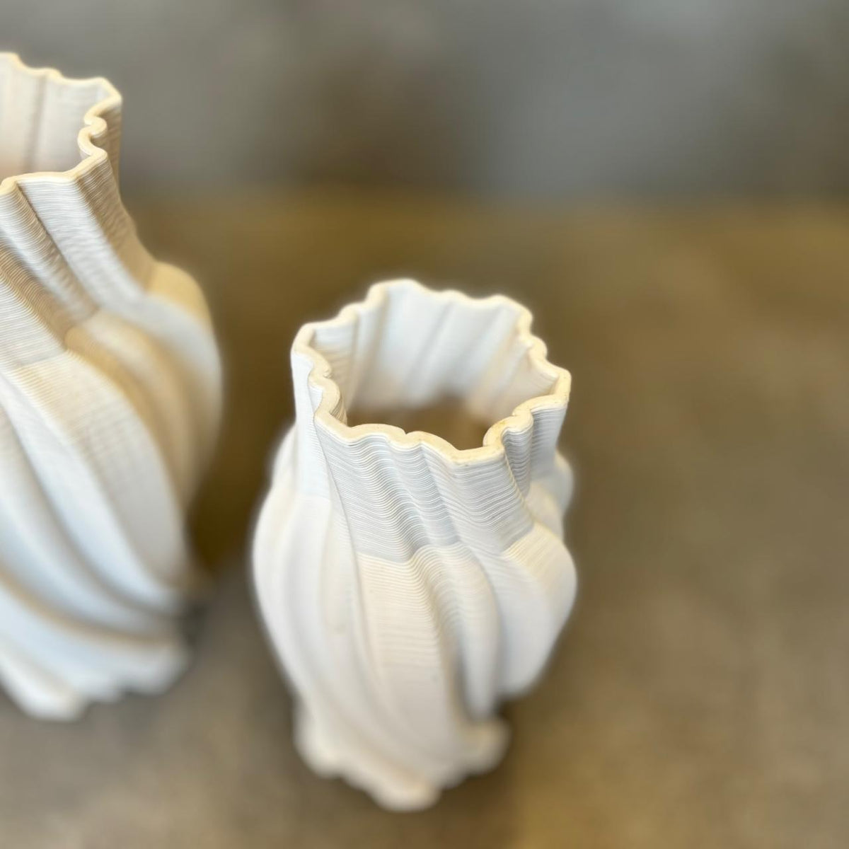 Close-up view of white spiral ribbed ceramic vases showcasing sculptural twisted detailing and textured matte finish.