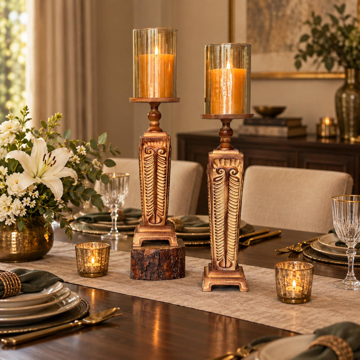 Elegant carved wooden hurricane candle holder set used as a luxury dining table centerpiece with glass shades and pillar candles.